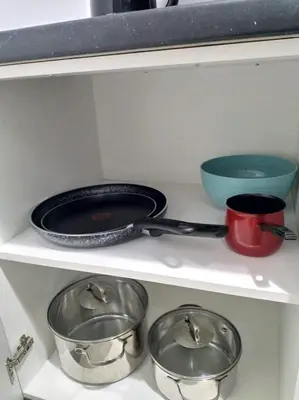 three pots and pans on a shelf in a kitchen at A convenient apartment in the heart of Athens in Athens