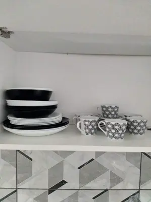 a shelf with plates and cups on top of it at A convenient apartment in the heart of Athens in Athens