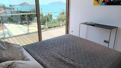 a bedroom with a bed and a view of the ocean at PORTO BLUE LUXURY APARTMENT in Porto Rafti