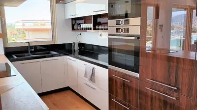 a kitchen with white cabinets and black counter tops at PORTO BLUE LUXURY APARTMENT in Porto Rafti