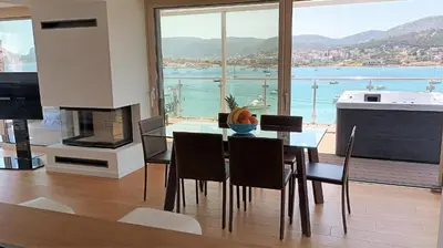 a dining room with a table and a view of the water at PORTO BLUE LUXURY APARTMENT in Porto Rafti