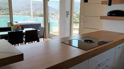 a kitchen with a counter top with a view of a room at PORTO BLUE LUXURY APARTMENT in Porto Rafti