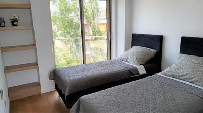 a bedroom with two beds and a large window at PORTO BLUE LUXURY APARTMENT in Porto Rafti