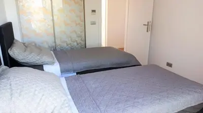 a bedroom with two beds and a closet at PORTO BLUE LUXURY APARTMENT in Porto Rafti