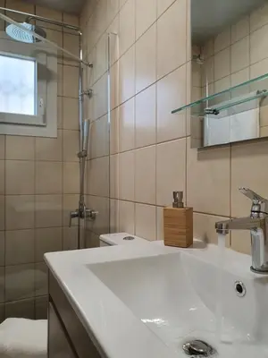 a bathroom with a white sink and a shower at Jasmine Villa in Vari