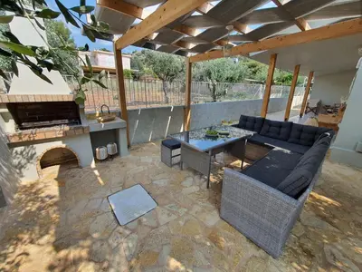 a patio with a couch and a table and a fireplace at Jasmine Villa in Vari