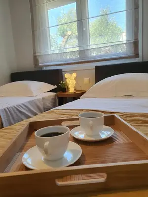 a tray with two cups of coffee on a bed at Jasmine Villa in Vari