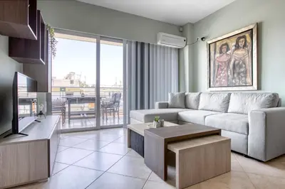 a living room with a couch and a tv at Sunny & cosy apt with balcony in Peristeri! in Athens