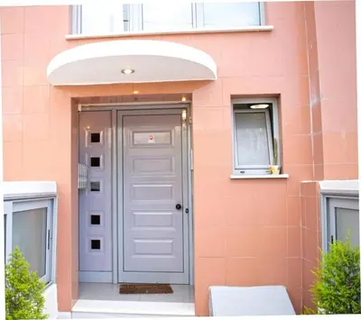 a pink building with a door and a window at Sunny & cosy apt with balcony in Peristeri! in Athens