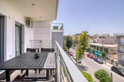 a balcony with a table and a view of a street at Sunny & cosy apt with balcony in Peristeri! in Athens