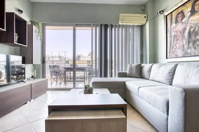 a living room with a couch and a table at Sunny & cosy apt with balcony in Peristeri! in Athens