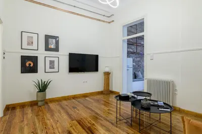 a living room with a table and a tv on a wall at Incomparable Plaka's Luxury Apt Private Pool in Athens