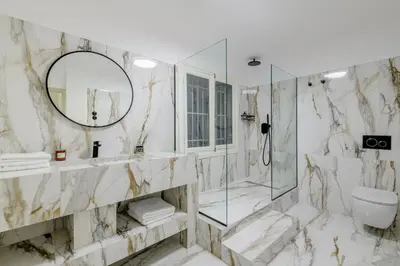 a marble bathroom with a shower and a mirror at Incomparable Plaka's Luxury Apt Private Pool in Athens