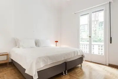 a white bedroom with a bed and a large window at Elegant 2 Bedroom 2 Bathroom Apartment in Athens Vibrant Centre! VL5 in Athens