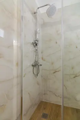 a bathroom with a shower with a glass door at Aphrodite Apartment in Athens