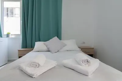 a white bed with towels on top of it at Aphrodite Apartment in Athens