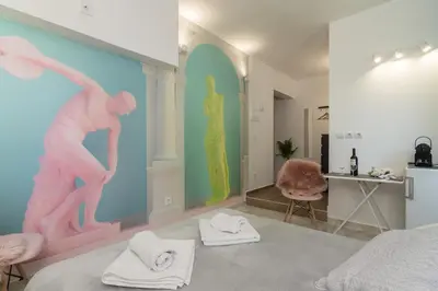 a bedroom with a bed with towels on the floor at Aphrodite Apartment in Athens