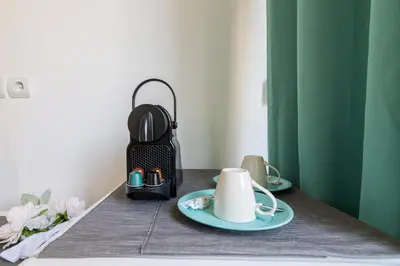 a table with a tea kettle and a cup on it at Aphrodite Apartment in Athens