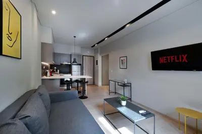 a living room with a couch and a kitchen at Porto Pireo By SuperHost365 Kolokotroni in Piraeus