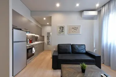 a living room with a couch and a kitchen at Porto Pireo By SuperHost365 Kolokotroni in Piraeus