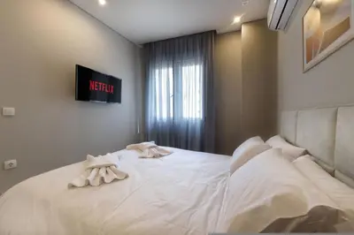 a bedroom with a white bed with towels on it at Porto Pireo By SuperHost365 Kolokotroni in Piraeus