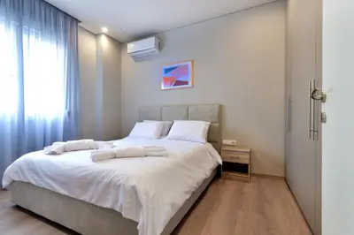 a bedroom with a bed with white sheets and a window at Porto Pireo By SuperHost365 Kolokotroni in Piraeus