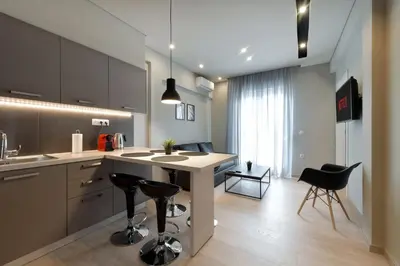 a kitchen with a counter and chairs in a room at Porto Pireo By SuperHost365 Kolokotroni in Piraeus