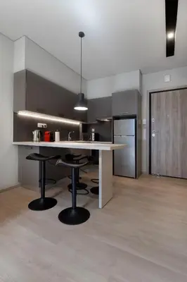 a kitchen with a large white table and black chairs at Porto Pireo By SuperHost365 Kolokotroni in Piraeus