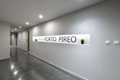 a white wall with a sign that reads puerto direo at Porto Pireo By SuperHost365 Kolokotroni in Piraeus