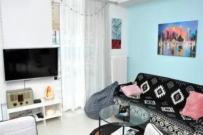 a living room with a couch and a flat screen tv at Koukaki sunshine roof apartment in Athens
