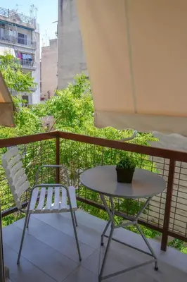 a table and a chair on a balcony at Marianna's Stylish Brand New Apt in the heart of Athens in Athens
