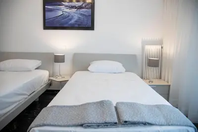 a bedroom with two beds and a picture on the wall at Marianna's Stylish Brand New Apt in the heart of Athens in Athens