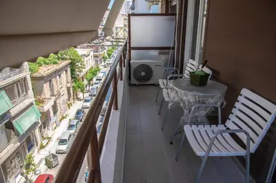 a balcony with a table and chairs and a view of a city at Marianna's Stylish Brand New Apt in the heart of Athens in Athens