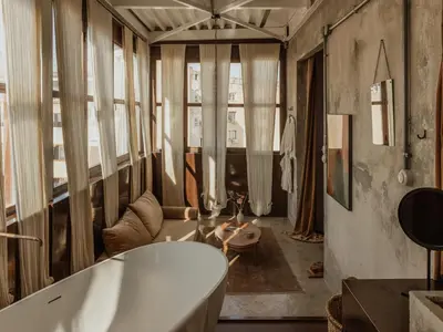 a bathroom with a tub and a table and some windows at Mona Athens in Athens