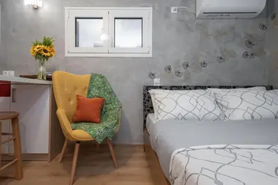 a bedroom with a bed and a chair and a desk at Cozy tiny apartment in the heart of Plaka in Athens