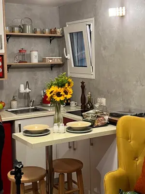 a kitchen with a table with a vase of flowers on it at Cozy tiny apartment in the heart of Plaka in Athens