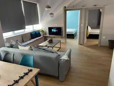 a living room with a gray couch and a tv at Athens Historical Centre 2 Bedroom Apt. in Athens