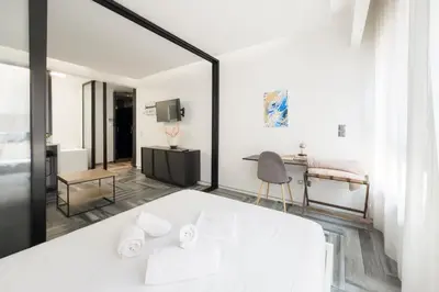 a bedroom with a large white bed and a mirror at Athenian Dream Suite in Athens