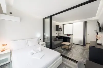 a bedroom with a large white bed and a living room at Athenian Dream Suite in Athens