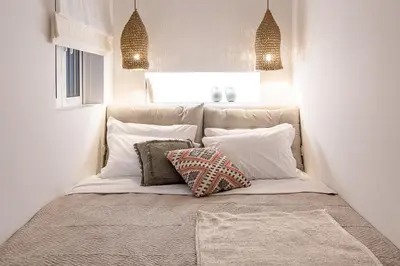 a bed with pillows on it in a room at LazySun in Sounio