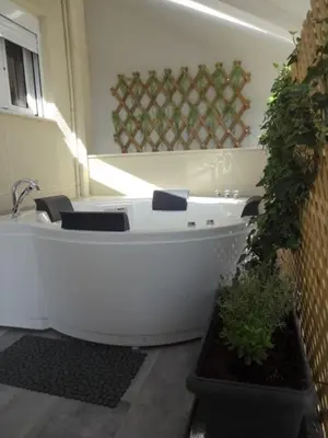 a white bath tub in a bathroom with a plant at Jenny's Dream Home -Acropolis Lux 2 Bedroom Apt, with Hot Tub, free Netflix, fast Wifi in Athens