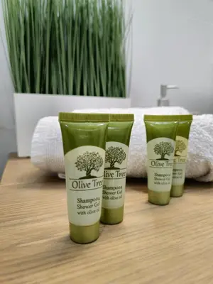 a group of three bottles of olive trees sunscreen on a table at Modern Garden View Apt in Voula, Athens - Luxe in Athens