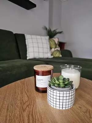 a table with a candle and a bowl of bananas on it at Modern Garden View Apt in Voula, Athens - Luxe in Athens