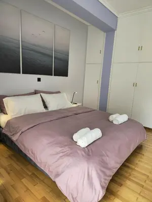 a bedroom with a large bed with two towels on it at Modern Garden View Apt in Voula, Athens - Luxe in Athens