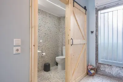 a bathroom with a door leading to a toilet at Athens Loft in Athens
