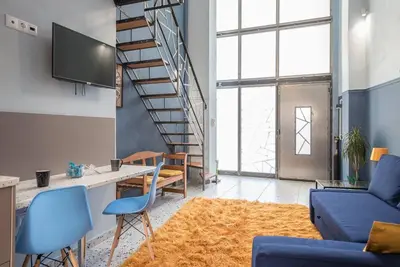 a living room with a blue couch and a staircase at Athens Loft in Athens
