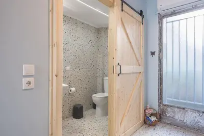 a bathroom with a door open to a toilet at Athens Loft in Athens