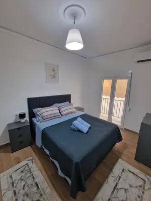 a bedroom with a large bed with a blue blanket at Luxury apartment in Sepolia in Athens