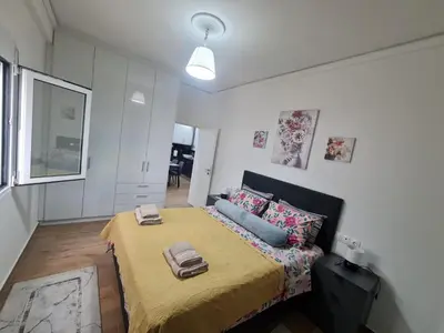 a small bedroom with a bed with a yellow blanket at Luxury apartment in Sepolia in Athens