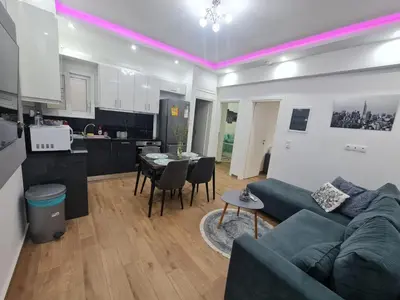 a living room and kitchen with a couch and a table at Luxury apartment in Sepolia in Athens